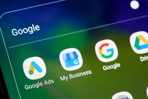 Auf einem Mobilgerät ist die Ikone von Google My Business zu sehen. Daneben ist die Ikone von Google Ads und daneben ist die Ikone von Google.